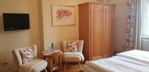 1 dormitorio con 1 cama, 2 sillas y mesa en Gasthaus Sternen Post en Oberried