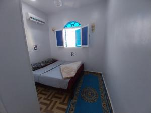 a small room with a bed and a window at Kayan Guest House in Aswan