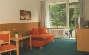 a living room with a red couch and a window at GesundheitsHotel Das Bad Peterstal in Bad Peterstal-Griesbach