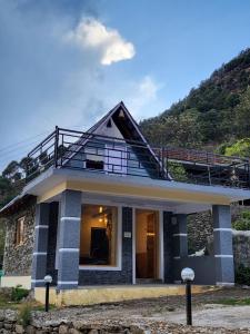 a house with a balcony on top of it at Neo Heaven's Stays BIR in Baijnāth