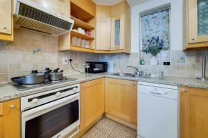 a kitchen with a stove and a sink at The Portman Residences in London