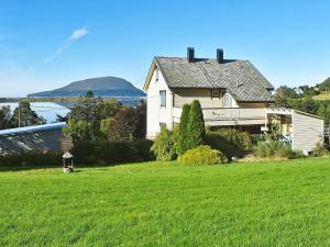 Holiday home Søvik في Syvik: منزل على تلة مع حقل أخضر