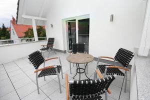 Un patio con sillas y una mesa en un balcón. en Ferienwohnung Christl, en Wustrow