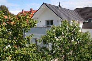 una casa blanca con árboles delante en Ferienwohnung Christl, en Wustrow