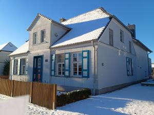una casa blanca con adornos azules en la nieve en Ferienwohnung Christl, en Wustrow 29 fotos más