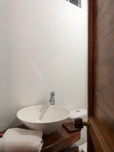 ein Badezimmer mit einem weißen Waschbecken und einem WC in der Unterkunft Suite Casa PALUM Studio Apartment in Palomino