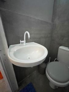 a bathroom with a white sink and a toilet at Pousada do Ade in Ilha do Mel