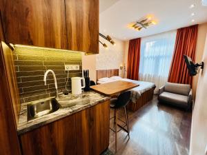 a kitchen with a sink and a room with a bed at Kyiv Panorama Apartments near Gulliver in Kyiv