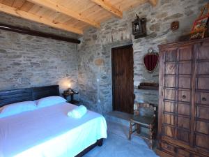a bedroom with a bed and a stone wall at Hill's Barbacane in Potamós