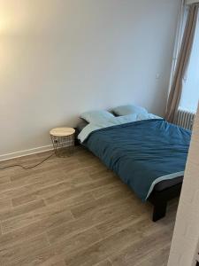 Schlafzimmer mit einem Bett und Holzboden in der Unterkunft Appartement haut standing région Lilloise in Roubaix