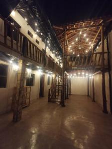 an empty room with lights on the ceiling and a room with stairs at Chale's House Hotel in San Juan del Sur