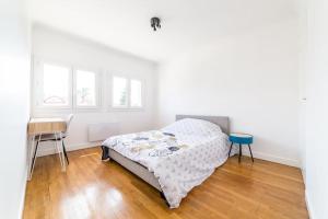 Schlafzimmer mit einem Bett, einem Tisch und Fenstern in der Unterkunft @Villa au coeur de Brive@ avec jardin et garage in Brive-la-Gaillarde
