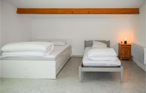2 Betten in einem weißen Zimmer mit einem Nachttisch und einem 6 x 6 cm großen Bett in der Unterkunft Nice Home In Jard-sur-mer With Wifi in Jard-sur-Mer