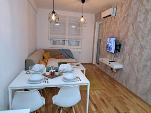 sala de estar con mesa blanca y sillas en Apartmani Kosic, en Banja Luka