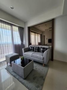 een woonkamer met een bank en een tafel bij Batam Luxurious, Breezy 1 bedroom! in Nongsa