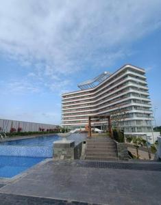 a large building with a swimming pool next to a building at Batam Luxurious, Breezy 1 bedroom! in Nongsa