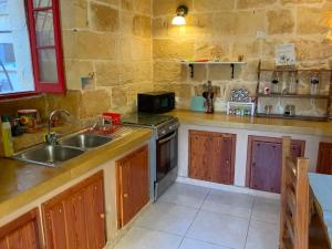 cocina con fregadero y fogones en Gozo Sunset Guesthouse, en Qala