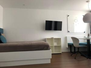 Dormitorio con cama, escritorio y TV en Sonniges Apartment mit Hallenbad und Sauna in Seefeld, en Seefeld in Tirol