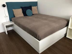 Bett in einem Schlafzimmer mit blauem Kopfteil in der Unterkunft Sonniges Apartment mit Hallenbad und Sauna in Seefeld in Seefeld in Tirol