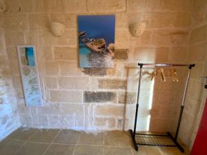 Habitación con pared de ladrillo en Gozo Sunset Guesthouse, en Qala
