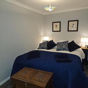 a bedroom with a large bed with blue sheets and pillows at Ground floor well appointed cosy flat in Ludlow in Ludlow