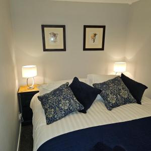 una camera da letto con un letto con cuscini e due lampade di Ground floor well appointed cosy flat in Ludlow a Ludlow