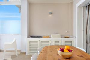 una cocina con una mesa de madera y un bol de fruta en Olbia Luxury Apartment en Olbia