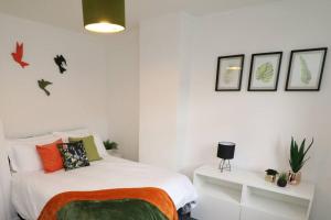 - une chambre avec un lit aux murs blancs et aux plantes dans l'établissement Cosy Two Bedroom Cottage, à Whitehaven