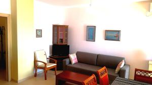 a living room with a couch and a chair at Turtle Apartment in Durrës