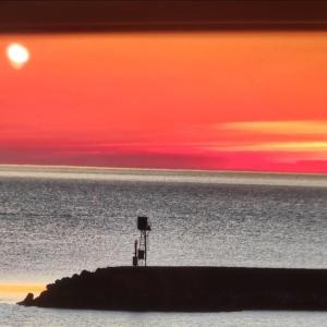 ポルト・サン・ジョルジョにあるHotel Il Timoneの日没の水の桟橋に立つ者
