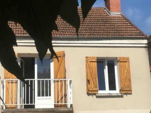 een wit huis met houten luiken en een balkon bij VerOliv : Superbe appartement rénové proche du centre-ville in Le Creusot