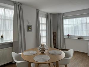 a dining room with a wooden table and white chairs at Fi-Eck Apartments in Waldeck