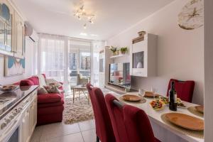 cocina y sala de estar con mesa y sillas rojas en Apartment Desert Rose en Split