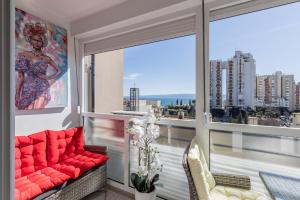 balcón con sofá rojo y ventana grande en Apartment Desert Rose en Split