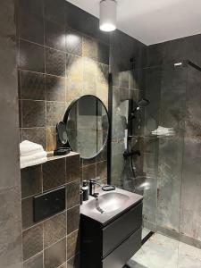 a bathroom with a sink and a shower with a mirror at Downtown Chic 2 in Iaşi