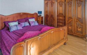 een slaapkamer met een houten bed met paarse lakens bij Awesome Home In Pfaffenheim With 2 Bedrooms in Pfaffenheim