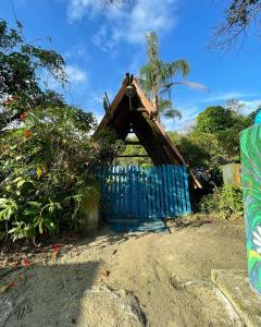 a small house with a blue gate in the sand at Pousada do Ade in Ilha do Mel