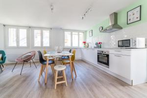 uma cozinha e sala de jantar com mesa e cadeiras em @Villa au coeur de Brive@ avec jardin et garage em Brive-la-Gaillarde