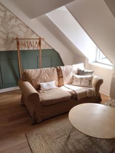 sala de estar con sofá y mesa en Perle rare, appartement paisible et cosy, en Lamballe