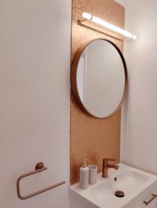 bagno con lavandino e specchio di Perle rare, appartement paisible et cosy a Lamballe