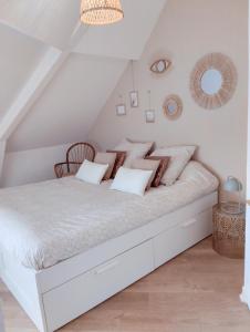 1 dormitorio blanco con 1 cama blanca grande con almohadas en Perle rare, appartement paisible et cosy, en Lamballe