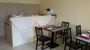 une cuisine avec une table, des chaises et un comptoir dans l'établissement Borgo San Giovanni, à Barcellona-Pozzo di Gotto