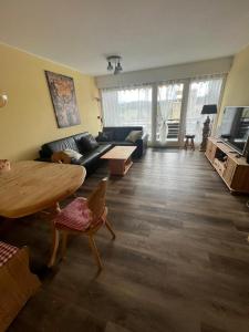 a living room with a couch and a table at Apartment Schwarzwald-Anni Pool Tennis Sauna in Obertal