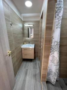 bagno con lavandino e specchio di AVR Airport Deluxe Suites 6 a Markopoulo