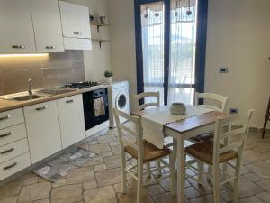 a kitchen with a table and chairs and a stove at Casa vacanze Barbera con piscina in Santa Lucia