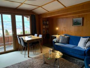 a living room with a blue couch and a table at Chalet Rosemarie in Ringgenberg