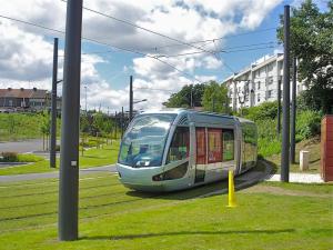 un tren está conduciendo por una calle en Superbe studio cosy spacieux au rez de chaussée, en Denain