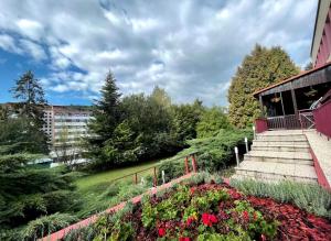 Penzion Zornicka في باردييوفشْكي كوبيلي: حديقة فيها ورد ودرج امام مبنى