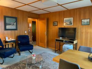 a living room with a tv and a table and chairs at Chalet Rosemarie in Ringgenberg