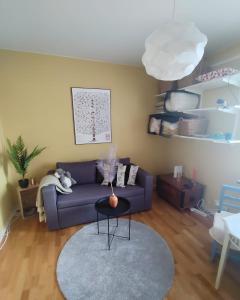 a living room with a purple couch and a table at Etta - Visby in Visby